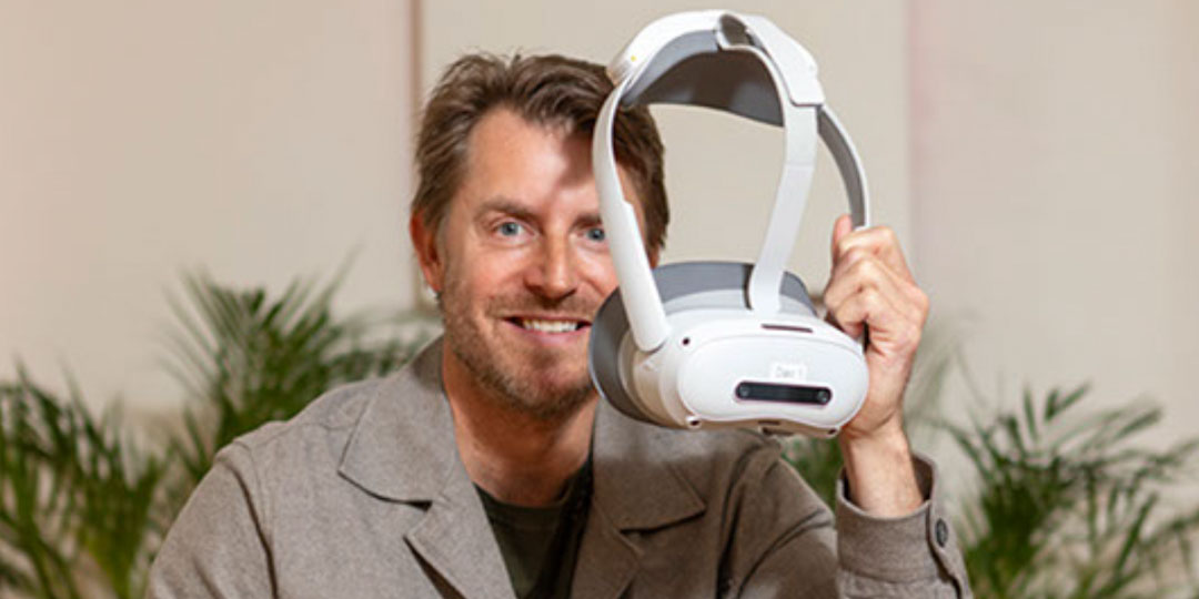 Man som håller upp ett par VR glasögon